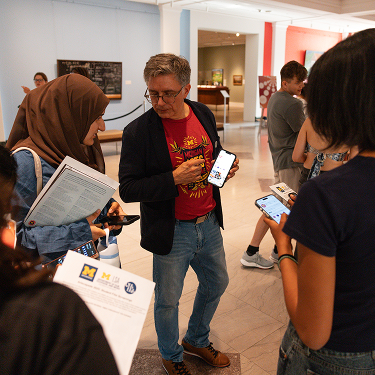 Mark Clague, Executive Director of the U-M Arts Initiative speaks to students in the Tisch Apse at Artscapade in UMMA, encouraging them to follow the Arts Initiative on social media.
